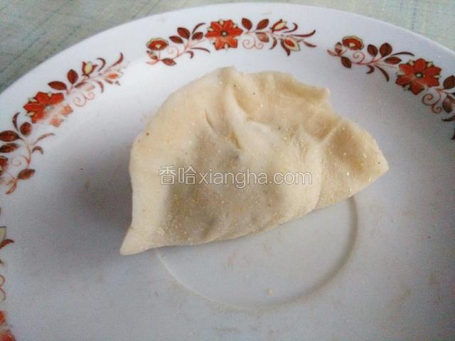 把饺子放在两只手的虎口处，握住饺子边缘往中间挤一下，一个饺子就做好了。
