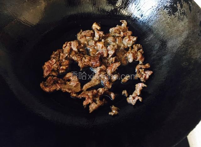 热锅倒入花生油烧至八成热，放入腌制好的牛肉炒至断生。