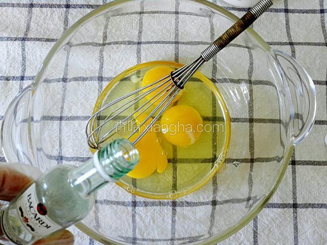 鸡蛋磕入碗中点1-2滴郎姆酒，在倒入白糖，用蛋抽打散至糖融化。