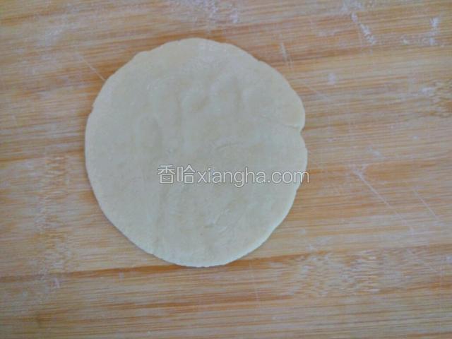 用手心按平，用擀面杖擀成中间厚两边薄的圆片，比饺子皮要厚