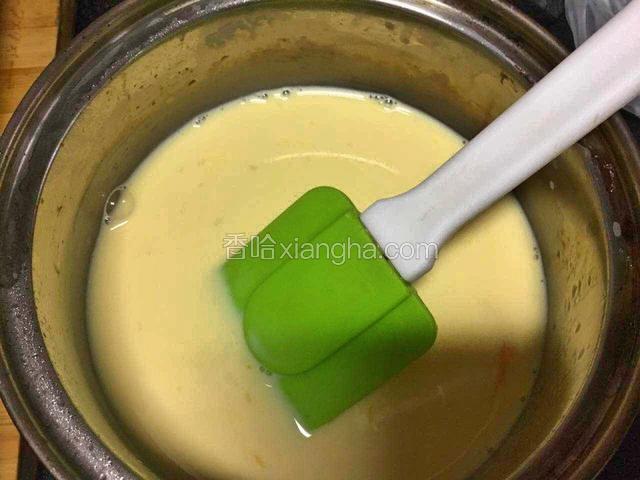 鸡蛋黄搅打散开之后慢慢加入牛奶液，搅拌均匀，漏筛过滤两次