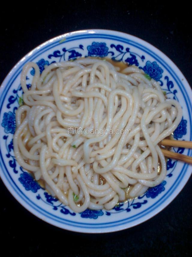 把捞入凉水盆里的面再捞入碗里，搅拌一下面能入味