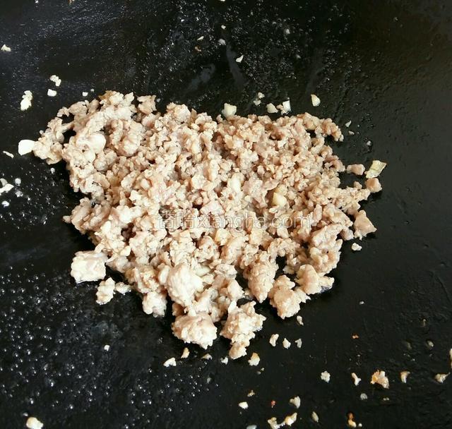 放肉末进去，用锅铲把肉末捣散。改用大火把肉末翻炒变色。倒少许酱油翻炒均匀。