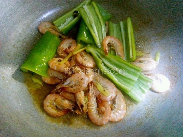 虾翻炒变色后，倒入辣椒，加一点盐和鸡精粉，翻炒至辣椒断生即可出锅。