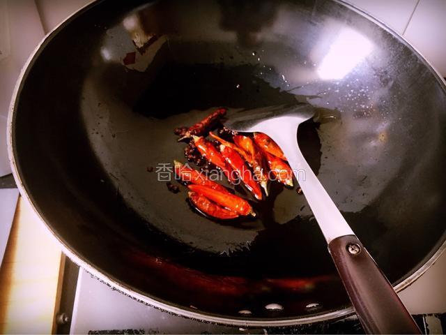 炒锅热油，倒入花椒、干红椒小火慢炸，待辣椒呈棕红色时捞出备用
