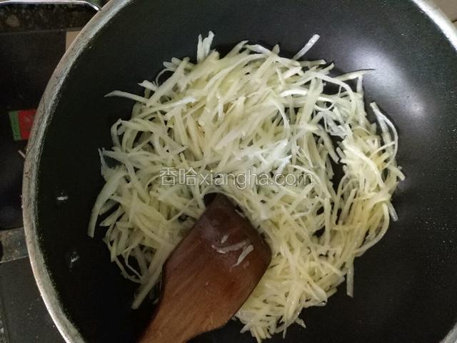 锅中放适量玉米油，下土豆丝大火翻炒两分钟。