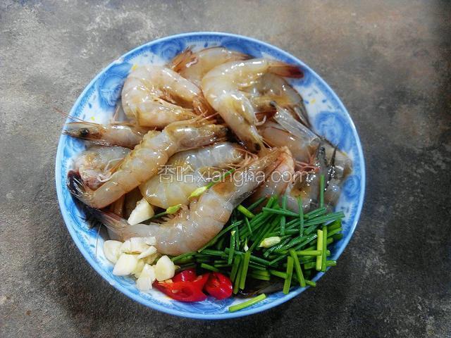 将虾洗净挑去虾线，韭菜花切小段，蒜姜切末，辣椒切斜片