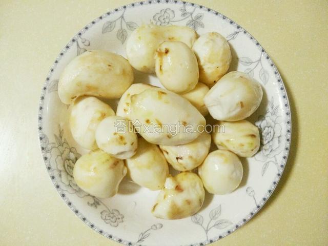 将芋头用不锈钢勺子刮皮，这是去皮的芋头如图（戴橡胶手套）
