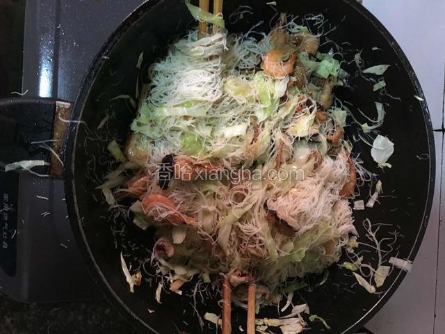 用两双筷子不停的翻动粉干