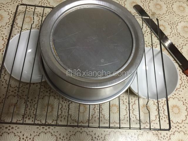 出炉之后举起模具摔几下，震出蛋糕体内的热气，然后迅速倒扣在网架上，同时也起到下拉的作用，防止蛋糕塌陷