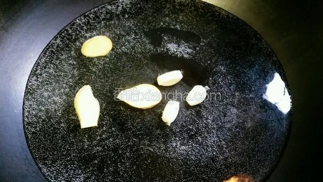 锅里下适量的水，下蒜瓣、姜片煮沸下食油