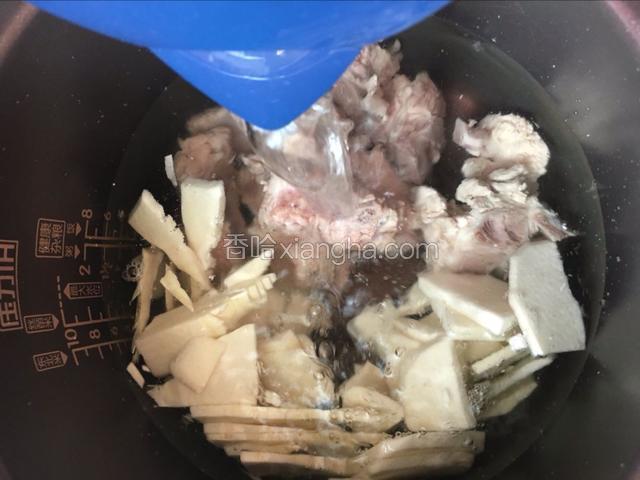 排骨捞出和竹笋一起放入锅中，加入适量水，启动煲汤键