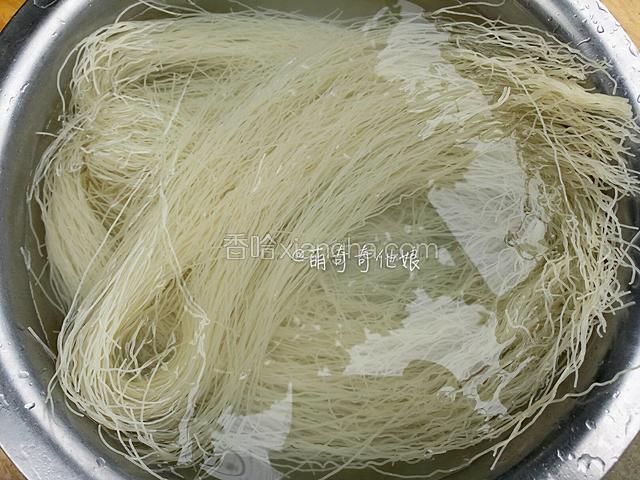 用冷水浸泡至软，如果盆太小装不下也不要把米面折断，可以慢慢压在水里变软后再把边缘压下去即可。
（如果用的挂面则省略此步骤，直接锅中烧开水，下挂面煮至六七成熟后捞出过冷水拨散后沥水即可，煮好的面条内芯应该大部分都还是白色的，别煮太熟。）