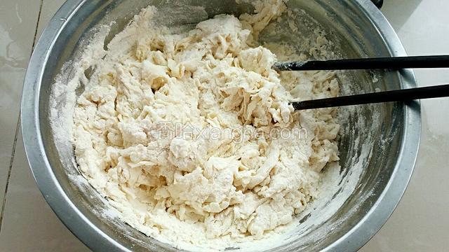 再划圈倒入温水，用筷子把面粉拌成棉絮状。
