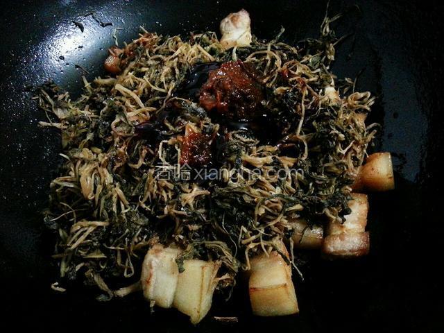 沥干油份，放入梅干菜，撒点盐，淋点料酒，耗油和六月鲜酱油，豆瓣酱