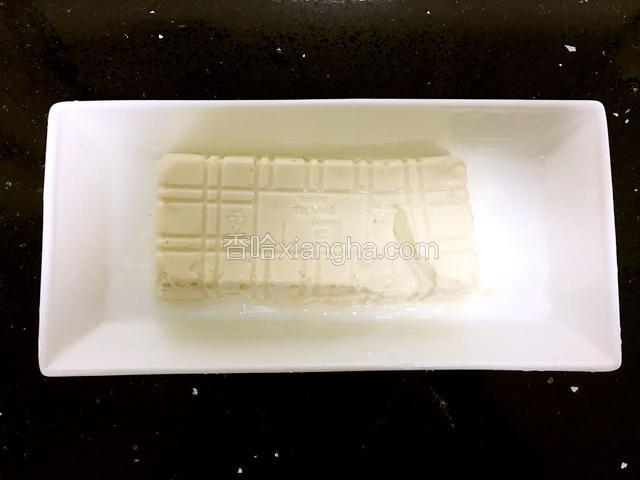 把内脂豆腐倒扣出来，沥干多余水份。