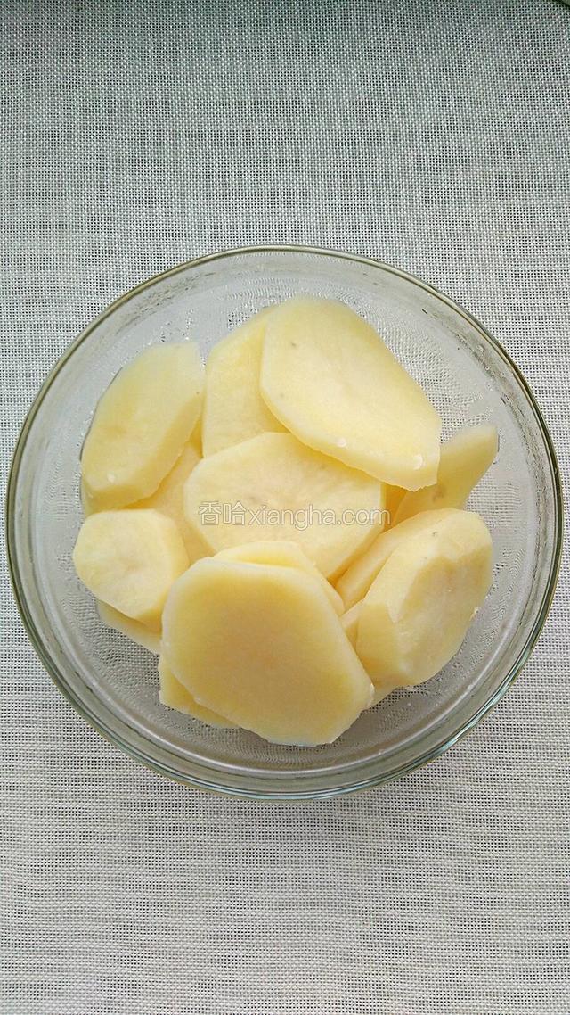 将土豆片倒入锅中用水煮熟后捞出沥干水。