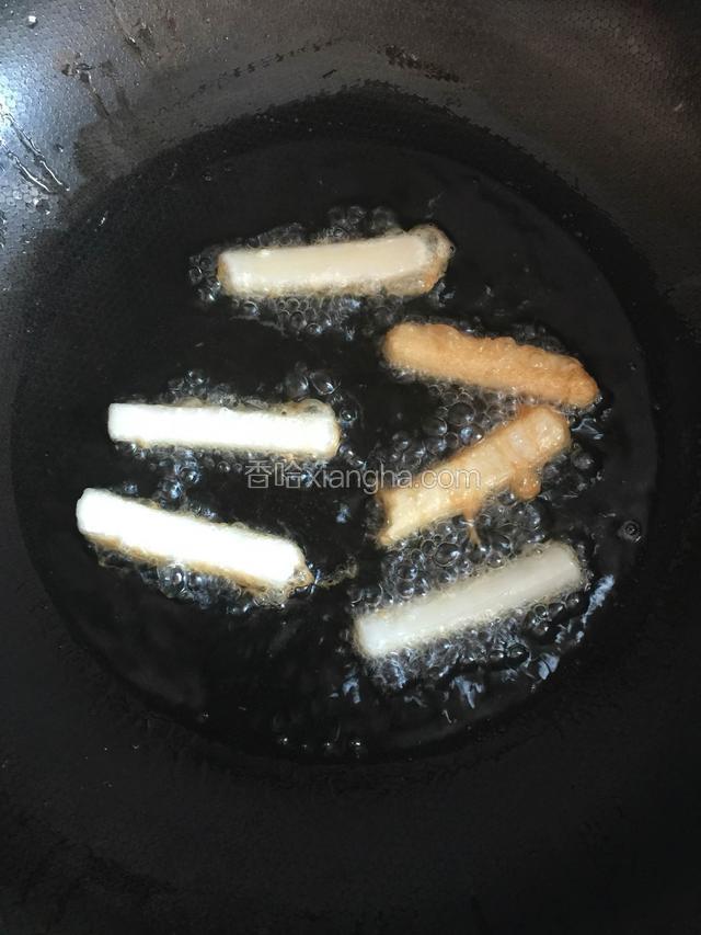 锅内油至7分热，粘有蛋液的年糕依次放入油锅炸