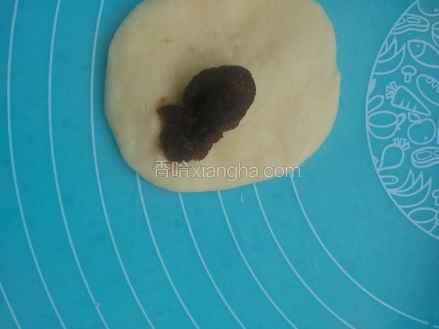 取一剂子揉圆按扁擀成圆形，包入豆沙馅