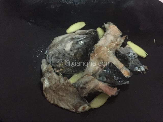 把三文鱼头煎至两面微黄然后加入姜片，