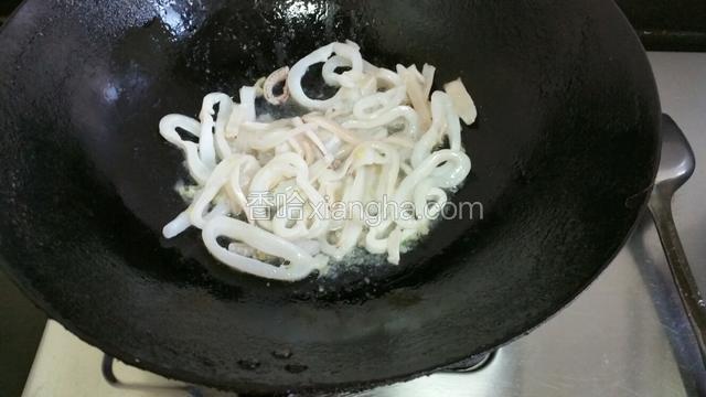 倒入鱿鱼翻炒片刻加料酒，再翻炒2分钟加点水