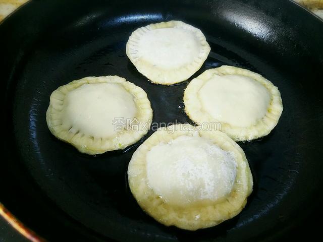 开大火将平底锅烧热，锅热后放入油，油五成热时改小火，放入馅饼。