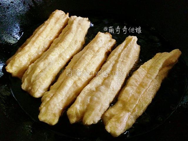 拉抻好一个油条就下到油锅里去，小火炸！小火炸！下油锅的油条生胚一瞬间会浮起来并膨大。用筷子拨动使之受热均匀，一面炸金黄后记得翻面！色泽金黄就好了，可以捞起了。
（油温一定要够热，油条胚放入能马上浮起来，炸制过程中要不断翻动，使油条充分膨胀。）