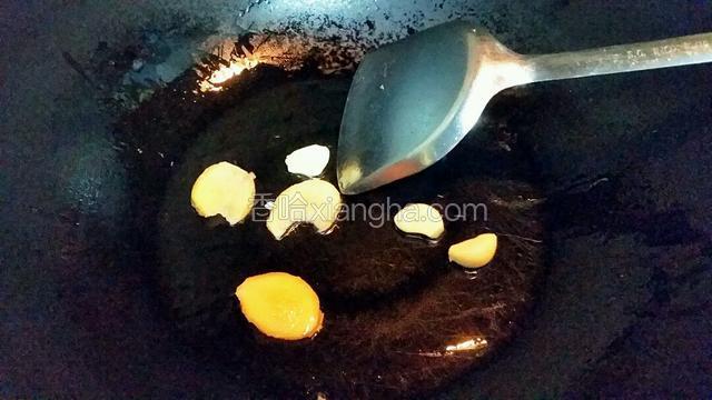热锅下食油，下蒜瓣和姜片炒香
