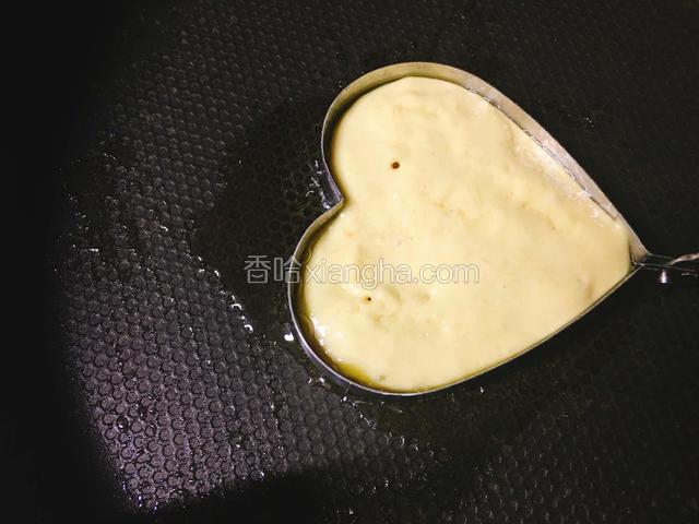倒入一勺芒果面糊，大火定型，转小火煎至四周有油渗出。