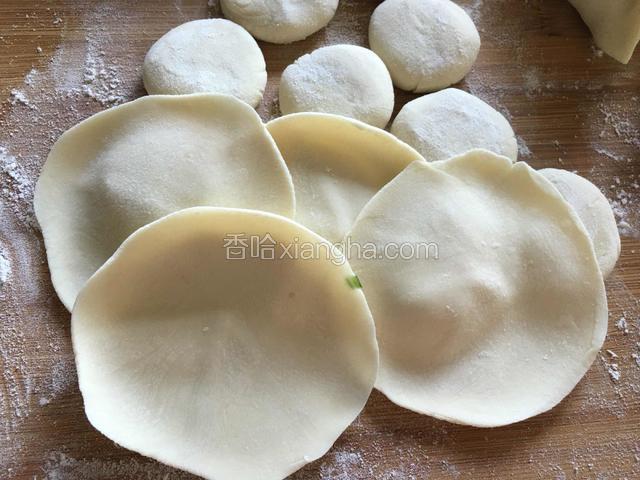 按扁，用擀面杖擀成中间厚边缘薄的饺子皮。