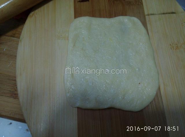 用擀面杖擀成方形薄饼。