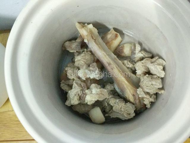 将焯过水的羊肉、羊骨连生姜一起装进炖锅。