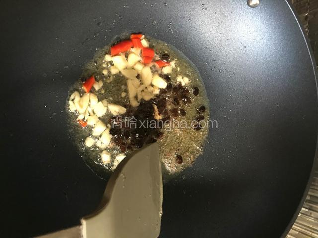 油锅烧热后放入大蒜和辣椒还有豆豉炒香