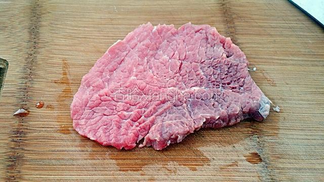 把牛里脊肉洗净后，用刀背把肉的两面拍松。