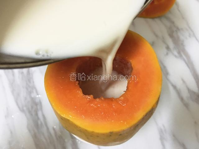 把摊冷的牛奶倒入木瓜中