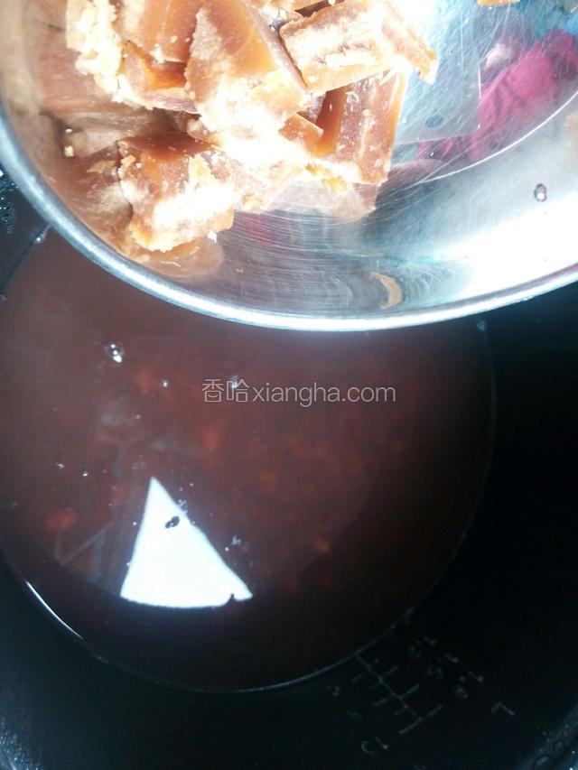打开锅盖，把红冰糖倒进。