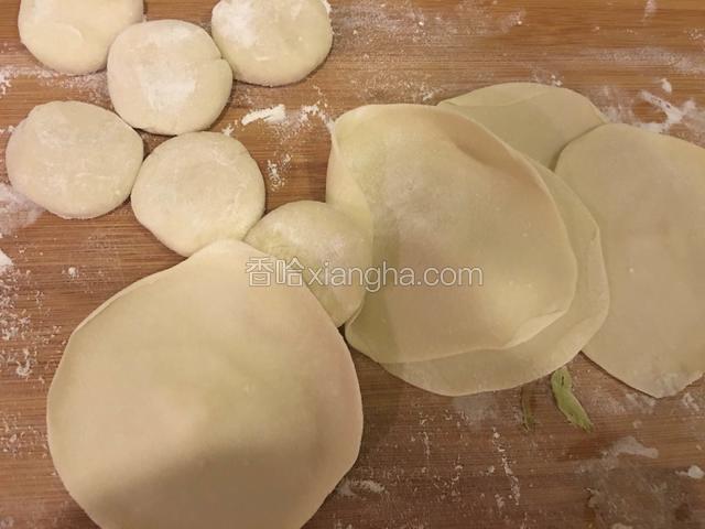 把剂子按扁，先擀成中间厚边缘薄的饺子皮。
