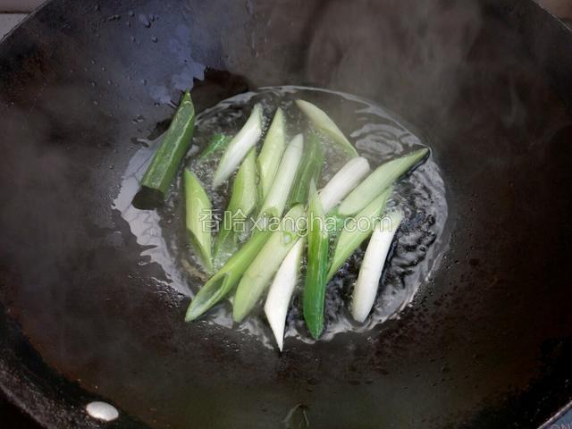 锅里烧热油，先下入葱段
