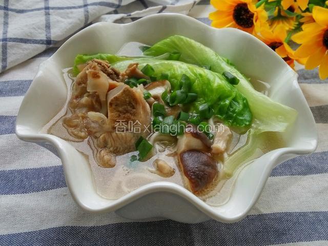 在把煲好的猪骨汤，用勺子盛入面条碗中，撒上葱花即可