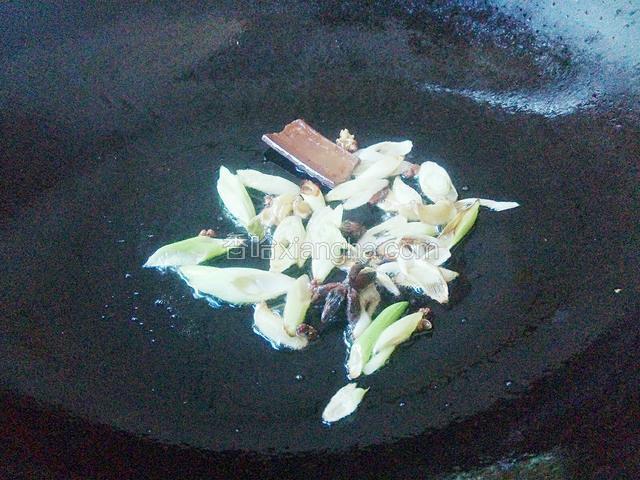 利用炸肉的油来炒酸菜，先把适量葱片和花椒姜片桂皮八角炒香。
注：桂皮和八角是汤锅里捞出来的，用来煮过肉的，不要浪费，还可以用。