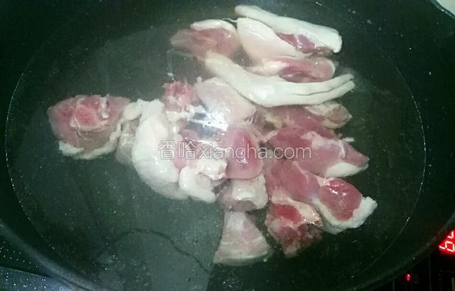 把鸭肉凉水下锅 倒入点料酒  