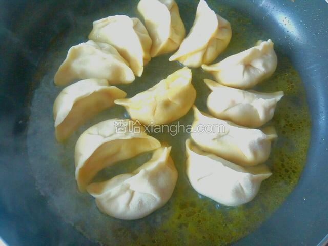 加入清水，液位在饺子的下1/3处，盖上锅盖小火煎。