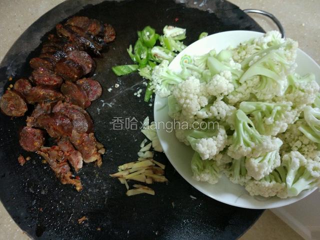 准备下食材，香肠切片，辣椒切菱形，大蒜切片，姜切丝，花菜切一小朵一小朵的！备用！