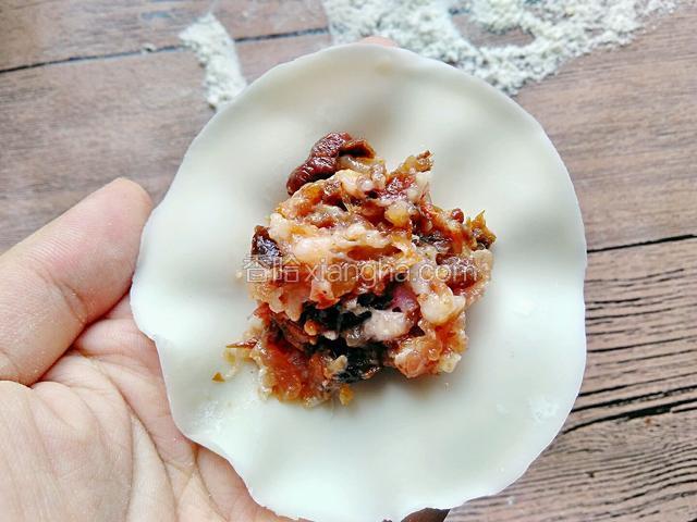 取一张饺子皮，放入适量的馅料。