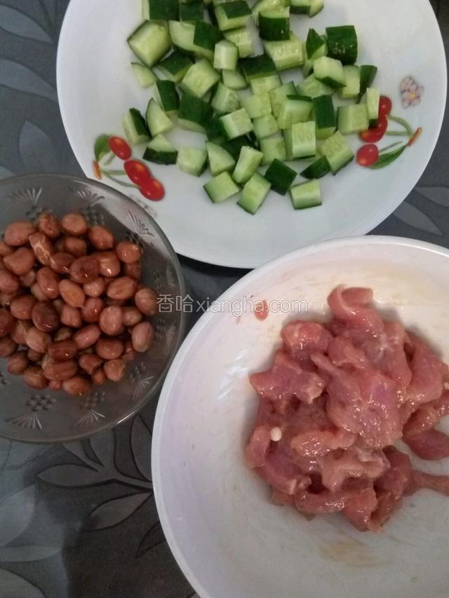 提前把猪肉洗净切成丁，放入碗内加入适量料酒，生抽，生粉抓匀腌制一个小时。黄瓜洗净切成丁，花生米炸熟