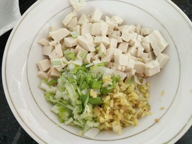 豆腐用开水烫一下，晾凉了以后切丁，葱姜末放入一个碗中备用。