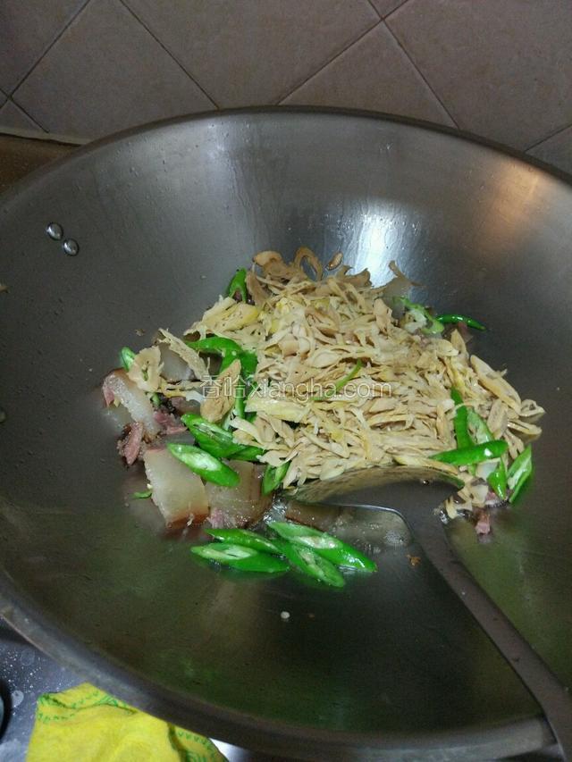 把腊肉放入翻炒片刻，再把冬笋和青辣椒放入，一起翻炒两分钟左右！