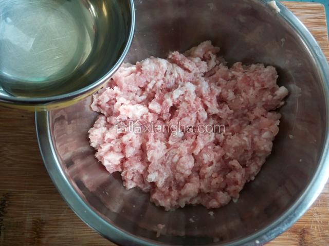 把花椒水倒进，剁碎猪肉里搅拌