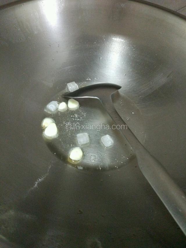 两面金黄，捞起沥干油！留少量油在锅里，放冰糖慢慢融化，把大蒜也放入爆香！