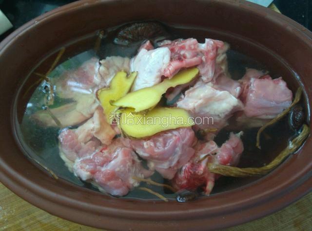 把鸭肉倒在茶树菇上面，加姜片、料酒和适量水。